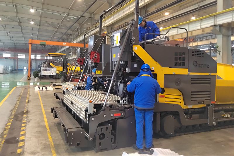 011738395779745128.jpeg 1、工人们抓紧时间总装即将出口的沥青混凝土摊铺机.jpg